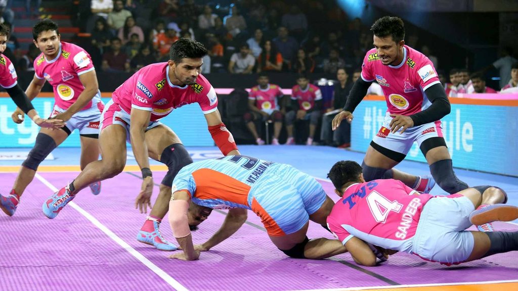 Jaipur Pink Panthers' Sandeep Dhull executes a tackle as teammate Deepak Hooda moves in to strengthen the defence.