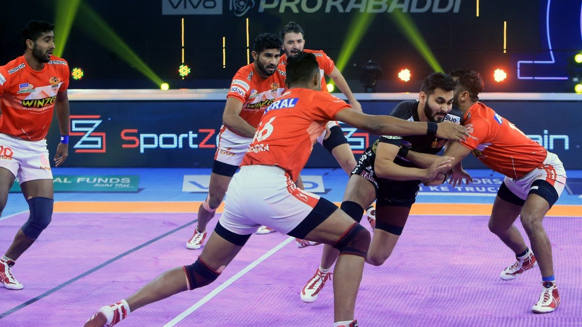 Rajnish of Telugu Titans is stopped by the Gujarat Giants' defenders in Match 105 of VIVO Pro Kabaddi League Season 8