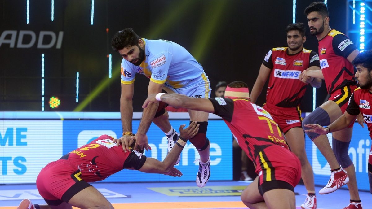 Pardeep Narwal of U.P. Yoddhas takes the aerial route to get past two defenders of Bengaluru Bulls in Match 87 of VIVO Pro Kabaddi League Season 8