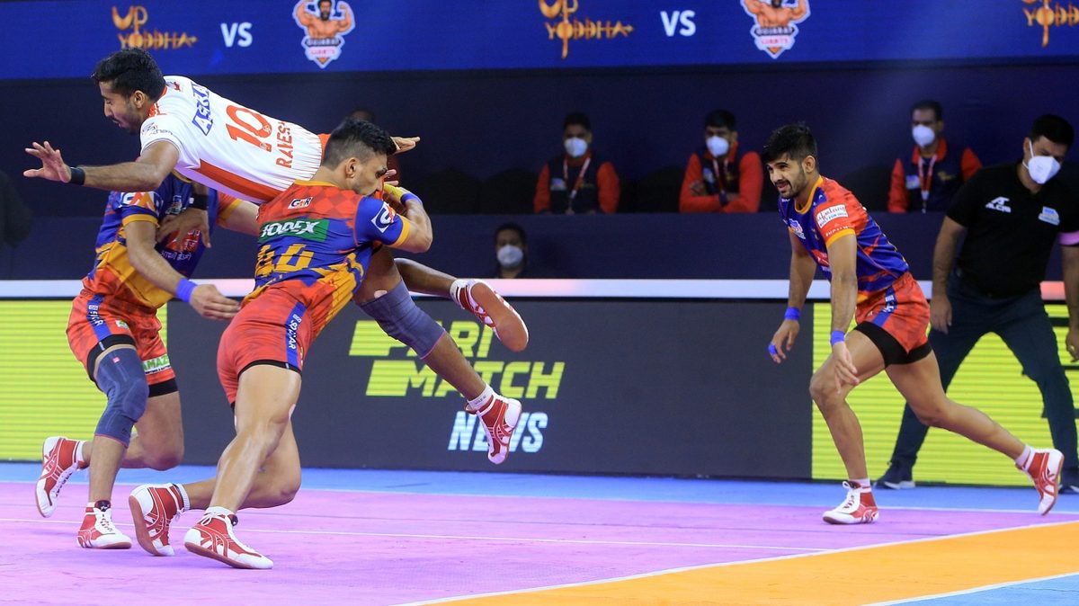 Rakesh of Gujarat Giants tries to leap over the U.P. Yoddha's defenders in Match 115 of VIVO Pro Kabaddi League Season 8