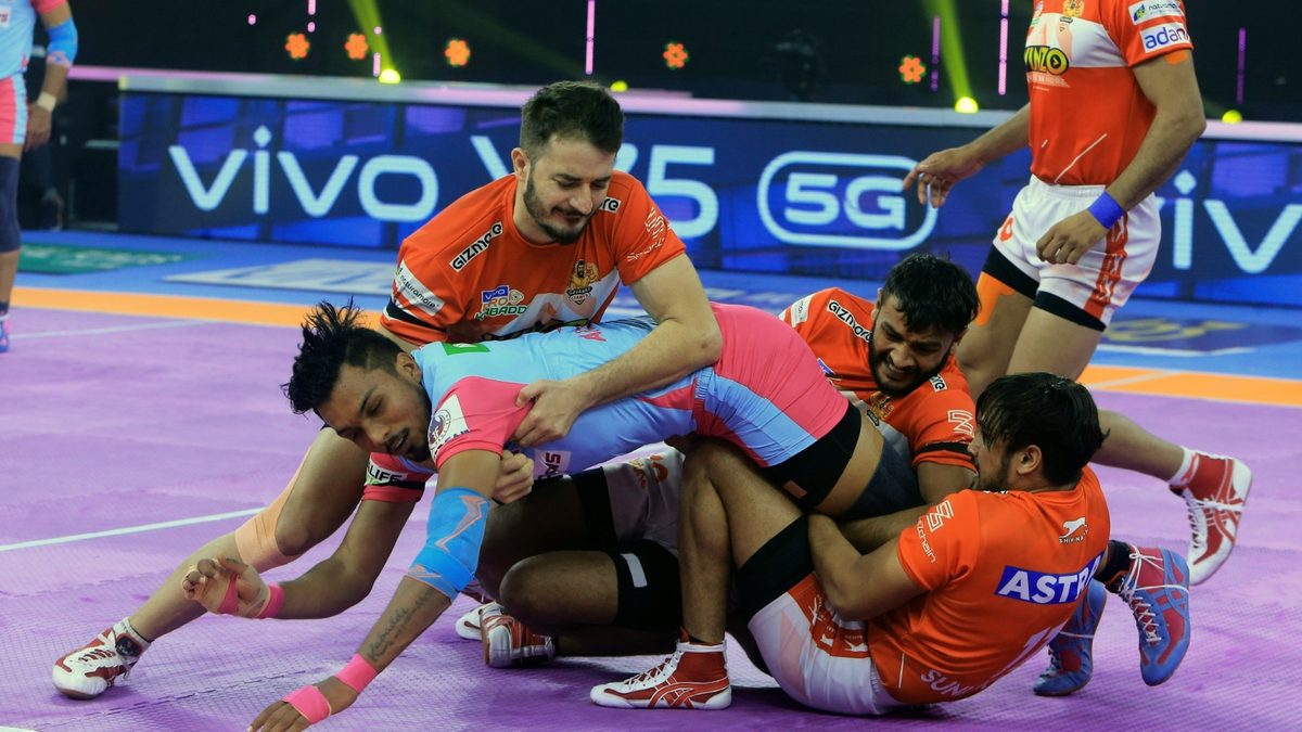 Arjun Deshwal of Jaipur Pink Panthers is grabbed by the Gujarat Giants' defense in Match 100 of VIVO Pro Kabaddi League Season 8